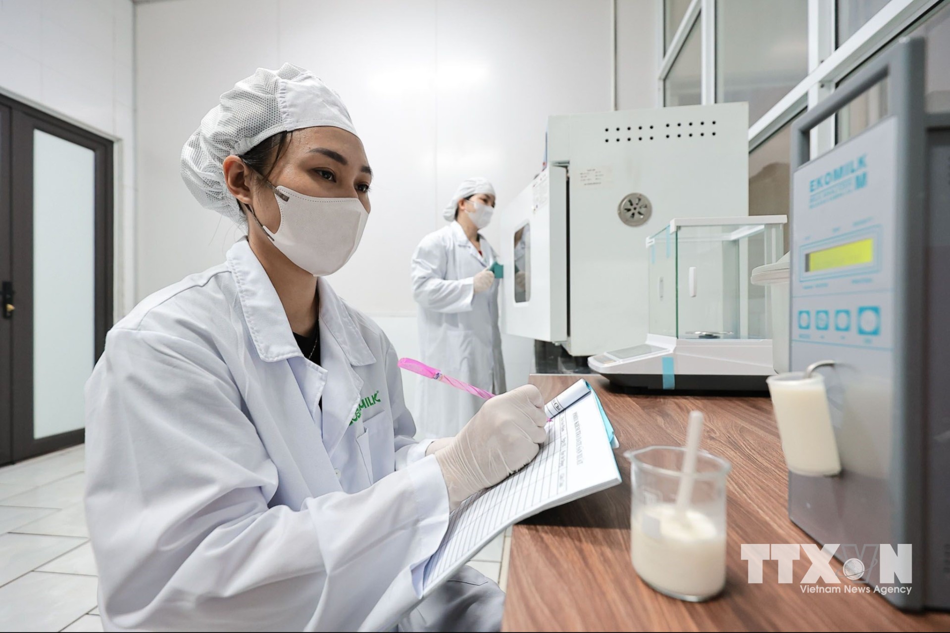 Kỹ thuật viên sử dụng thiết bị Ekomilk phân tích các chỉ tiêu chất lượng, thành phần hóa học của sữa tươi trước khi đưa vào sản xuất. (Ảnh: Lê Đông/TTXVN)